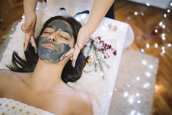 La aplicación de la máscara facial a la cara de la mujer en el salón de belleza — Foto de Stock