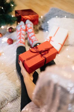 Parlak bluzlu kadın Noel hediyesini tutuyor.