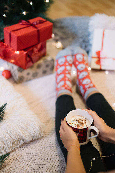 Woman warming her hand on hot coffee mug