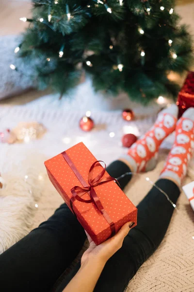 Vista dall'alto delle gambe delle donne con regalo vicino all'albero di Natale — Foto Stock
