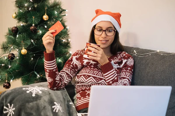 Mujer joven cerca del árbol de Navidad listo para comprar en línea —  Fotos de Stock