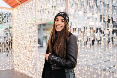 Kış şapkalı güzel kadın, dışarıda dururken gülümsüyor.