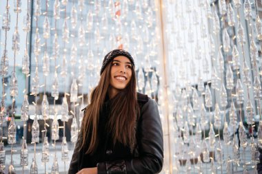 Gülümseyen kadın ışıklarla çevrili.