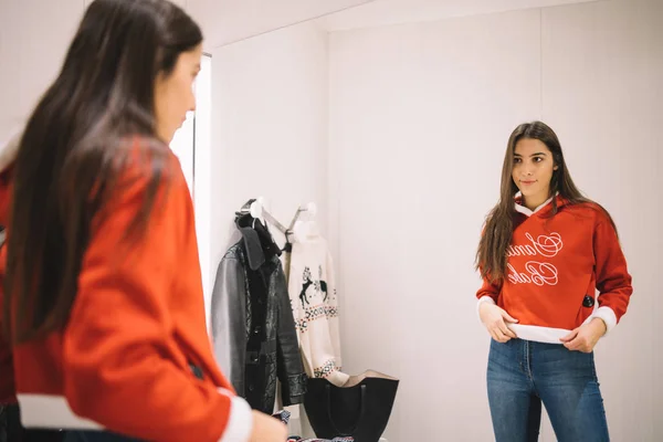 Woman trying new sweater in dressing room