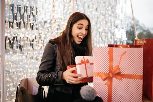 Surprised woman looking into opened Christmas gift box