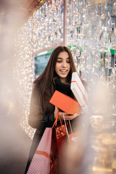 Молодая женщина заглядывает в открытую подарочную коробку — стоковое фото