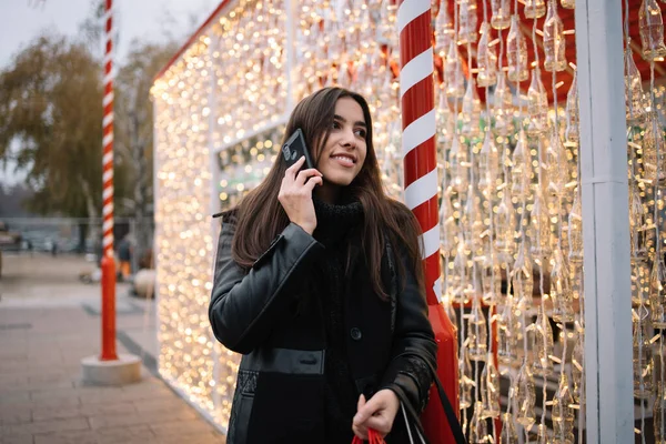 Flicka hålla väskor och prata på sin mobiltelefon — Stockfoto