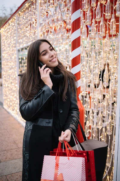 Fille heureuse tenant des sacs et parlant au téléphone — Photo