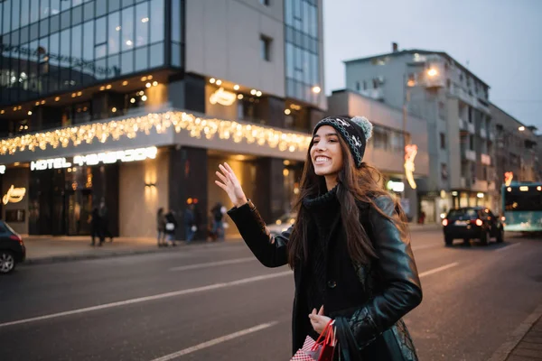 Sonriente chica con sombrero saludando para taxi — Foto de Stock