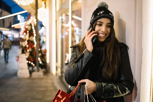 Woman talking on the phone and blurred Christmas tree