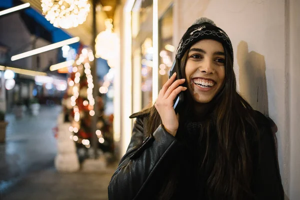 Chica feliz hablando por teléfono y fuera de foco árbol de Navidad —  Fotos de Stock