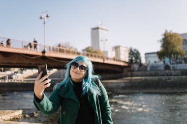 Solo turist kadın telefona bakıyor ve selfie çekiyor.