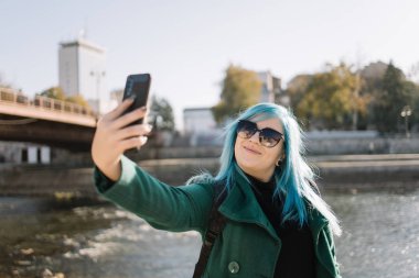 Odak dışı gülümseyen kadın selfie çekiyor.
