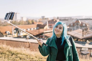 Genç turist kadın dışarıda selfie çekiyor.