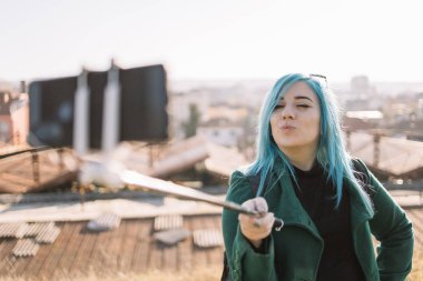 Gülümseyen kız selfie çekiyor ve barış işareti gösteriyor.