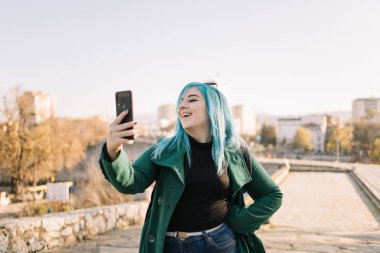 Gamzeli çekici bir kız, kendi fotoğrafını çekiyor.