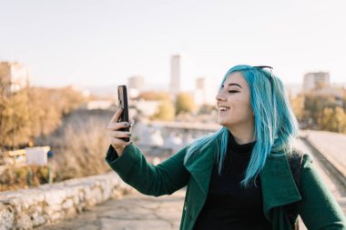 Güzel kız şehir manzaralı bir selfie çekiyor.