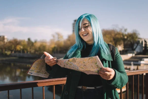 Turista mujer sonriendo y mirando mapa al aire libre —  Fotos de Stock