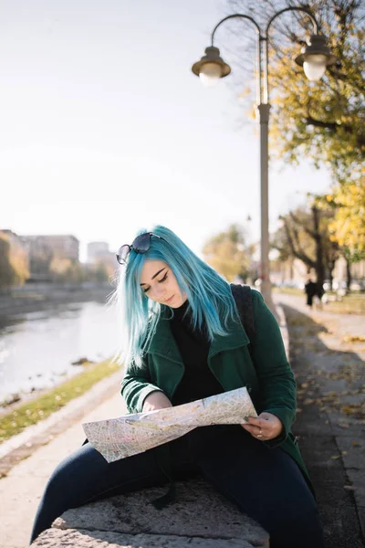 Smiling tourist woman with blue hair holding a map — 스톡 사진