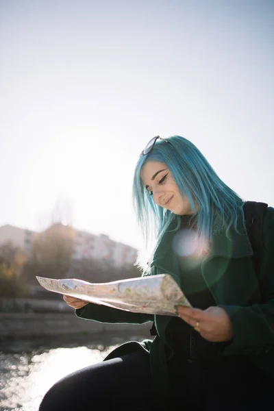 Ευτυχισμένο τουριστικό κορίτσι ψάχνει για κατεύθυνση σε ένα χάρτη — Φωτογραφία Αρχείου