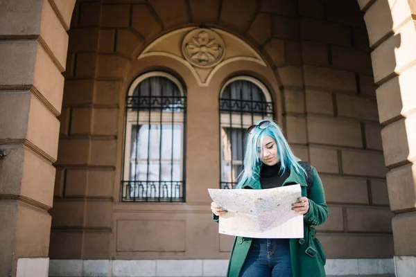 Chica sonriente mirando un mapa cerca del edificio — Foto de Stock