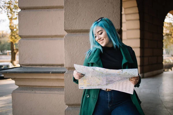 Woman holding map and looking into a camera