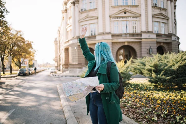 Mujer turista sonriente con mapa de papel ondeando — Foto de Stock