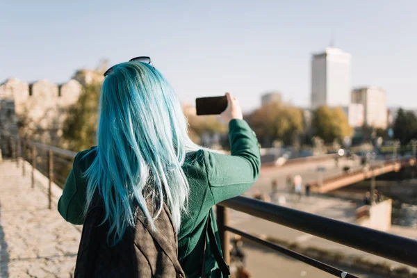 Atrás de fuera de foco chica haciendo selfie con en el teléfono de enfoque —  Fotos de Stock