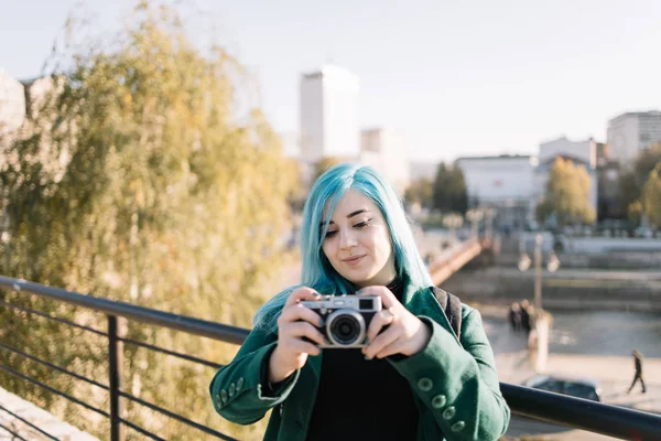 Kobieta patrząc na stary aparat fotograficzny w parku miejskim — Zdjęcie stockowe
