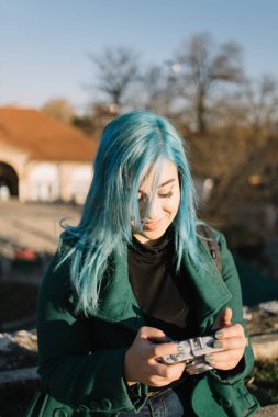 Gezgin kız elinde eski model fotoğraf makinesi tutuyor.