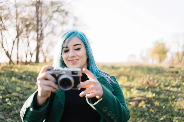 Smiling girl looking into vintage photo camera — 스톡 사진