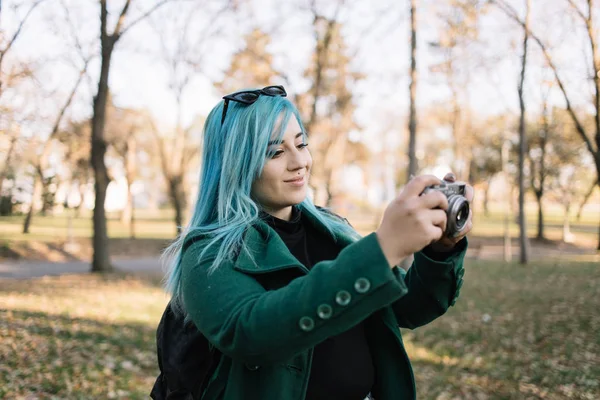 Dziewczyna z niebieskimi włosami robi zdjęcia w parku — Zdjęcie stockowe