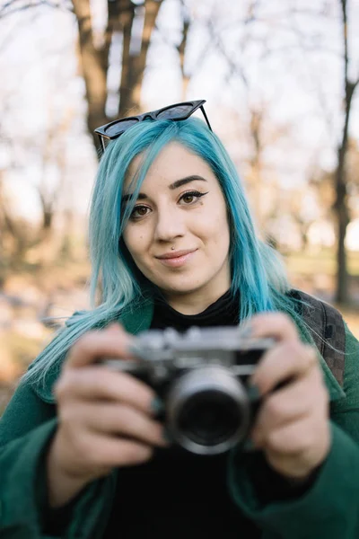 Kobieta trzyma rozmyty aparat fotograficzny i patrzy z przodu — Zdjęcie stockowe