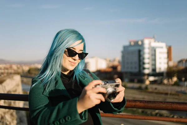 Tourist woman with sunglasses holding bridge camera