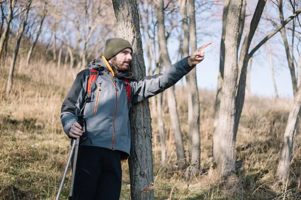 極を持つ観光客の男と山の方向を指す — ストック写真