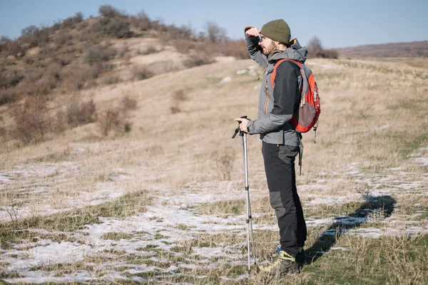 Male explorer standing on field and looking for location — Stock Photo, Image