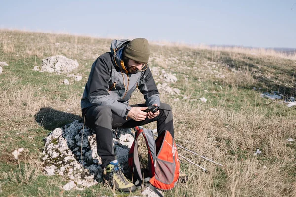 Homem aventureiro descansando na rocha com walkie-talkie montanha — Fotografia de Stock