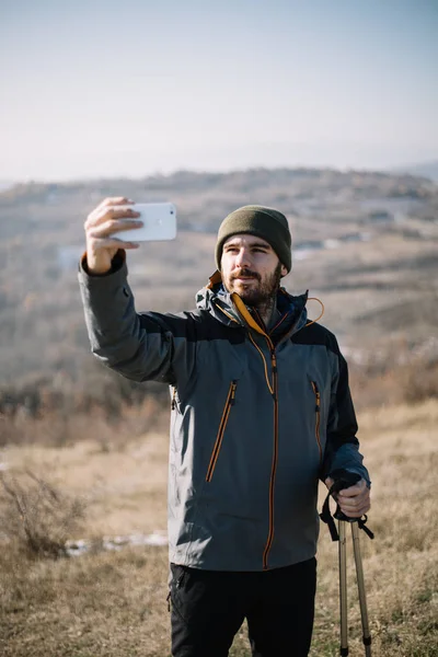 Tourist man taking photo of himself with smartphone