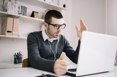 Sakallı iş adamı çevrimiçi toplantı yapıyor.