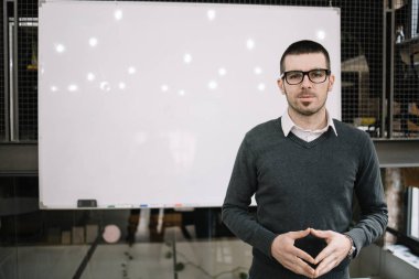 Sunucu beyaz tahtanın önünde duruyor.