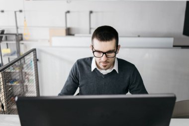 Ofiste çalışan gözlüklü bir çalışan.