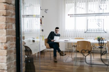 Çalışan erkek dinlenme odasında okuyor.