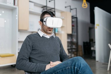 Girişimci otururken sanal gerçeklik gözlüklerini test ediyor