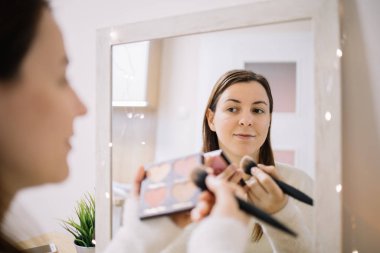 Kalp şeklinde fosforlu kalemler ve fırça tutan güzel bir kadın.