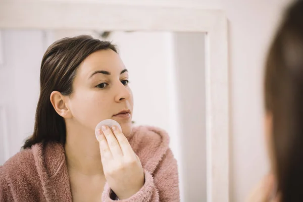 Mujer quitando maquillaje usando una almohadilla de algodón — Foto de Stock