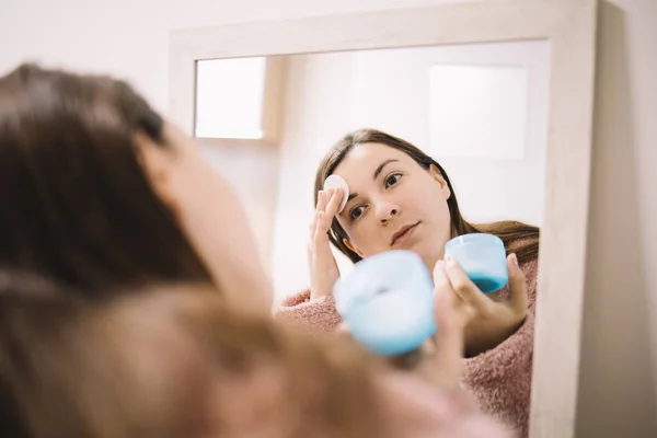 Imagen reflejada de la mujer limpiando su rostro — Foto de Stock