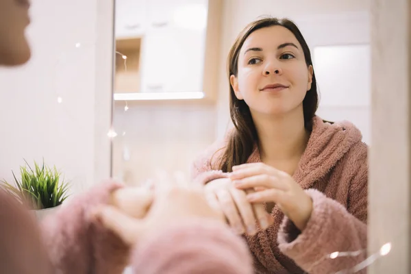 Reflejo del espejo de una mujer con albornoz — Foto de Stock