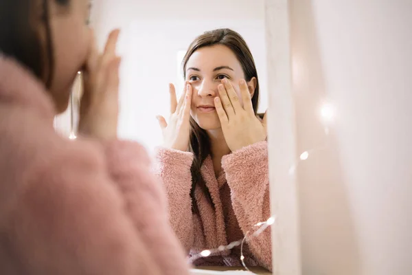 Jovencita masajeando su cara con las manos — Foto de Stock