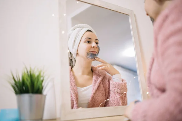 Vista lateral del espejo reflejo de una mujer con máscara facial — Foto de Stock