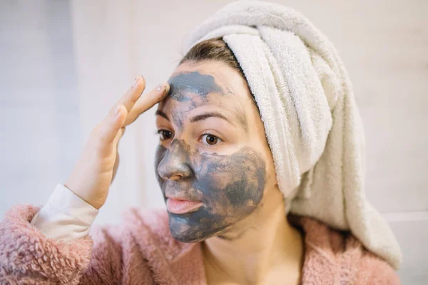 Mulher com carvão máscara facial vestindo turbante — Fotografia de Stock